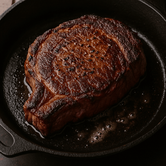 Perfectly seared ribeye steak sizzling in a cast iron skillet, showcasing a crusty exterior and juicy interior.