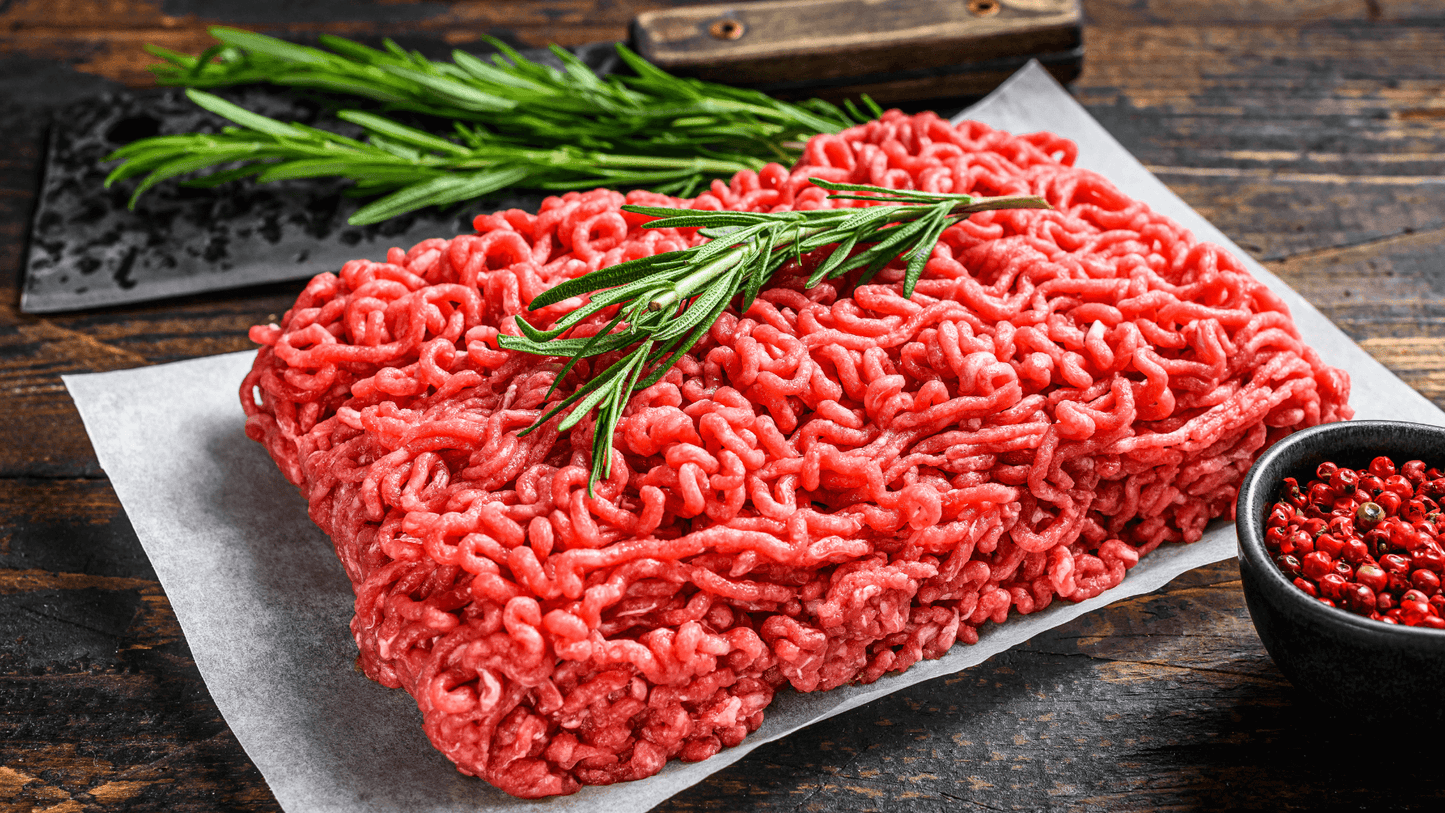 🥩 Grass Fed Ground Beef Bundle (2 lbs) displayed with fresh herbs on parchment paper.