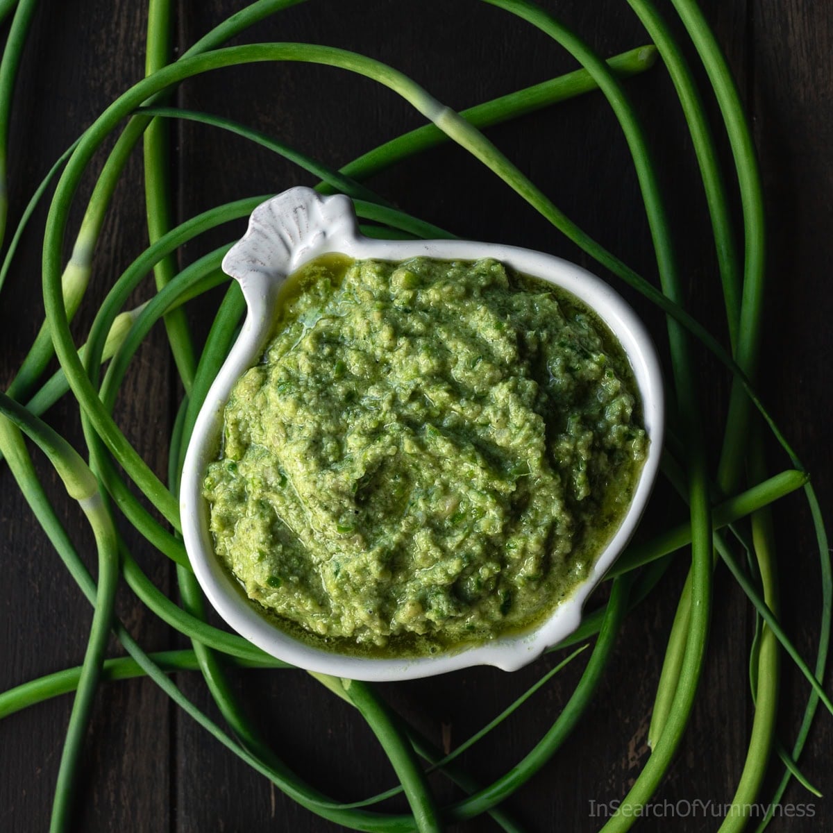 Garlic scape pesto in a bowl with fresh garlic scapes
