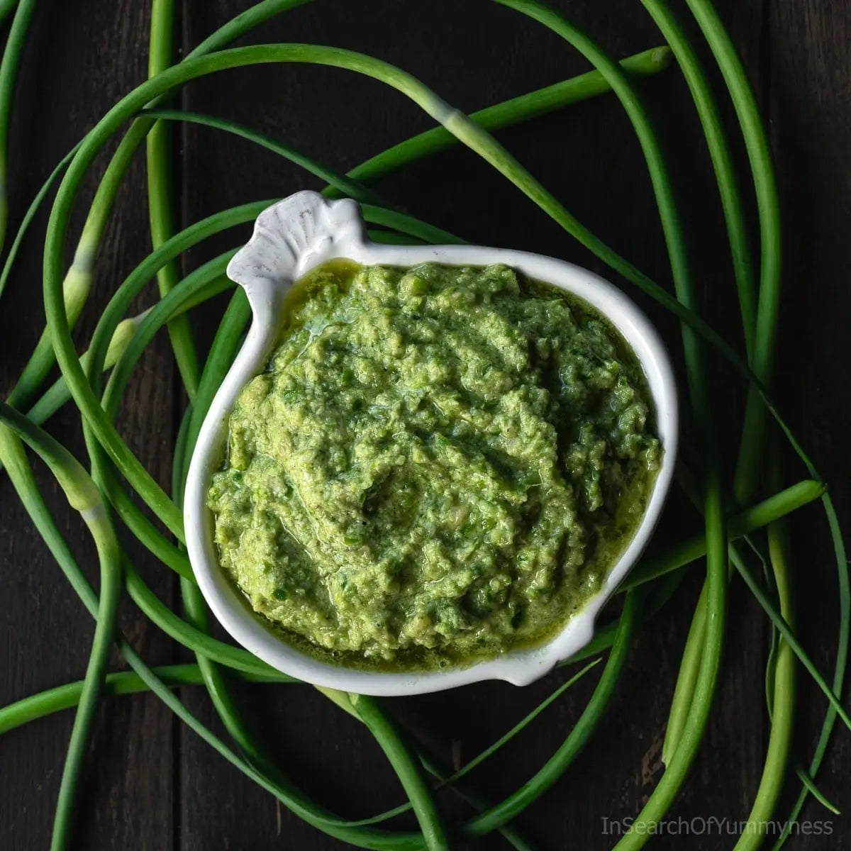 Garlic scape pesto in a bowl with fresh garlic scapes