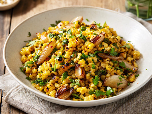 Charred corn and shallot salad with herb vinaigrette in a wide bowl