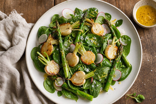 Roasted Hakurei turnip and asparagus salad on a white plate