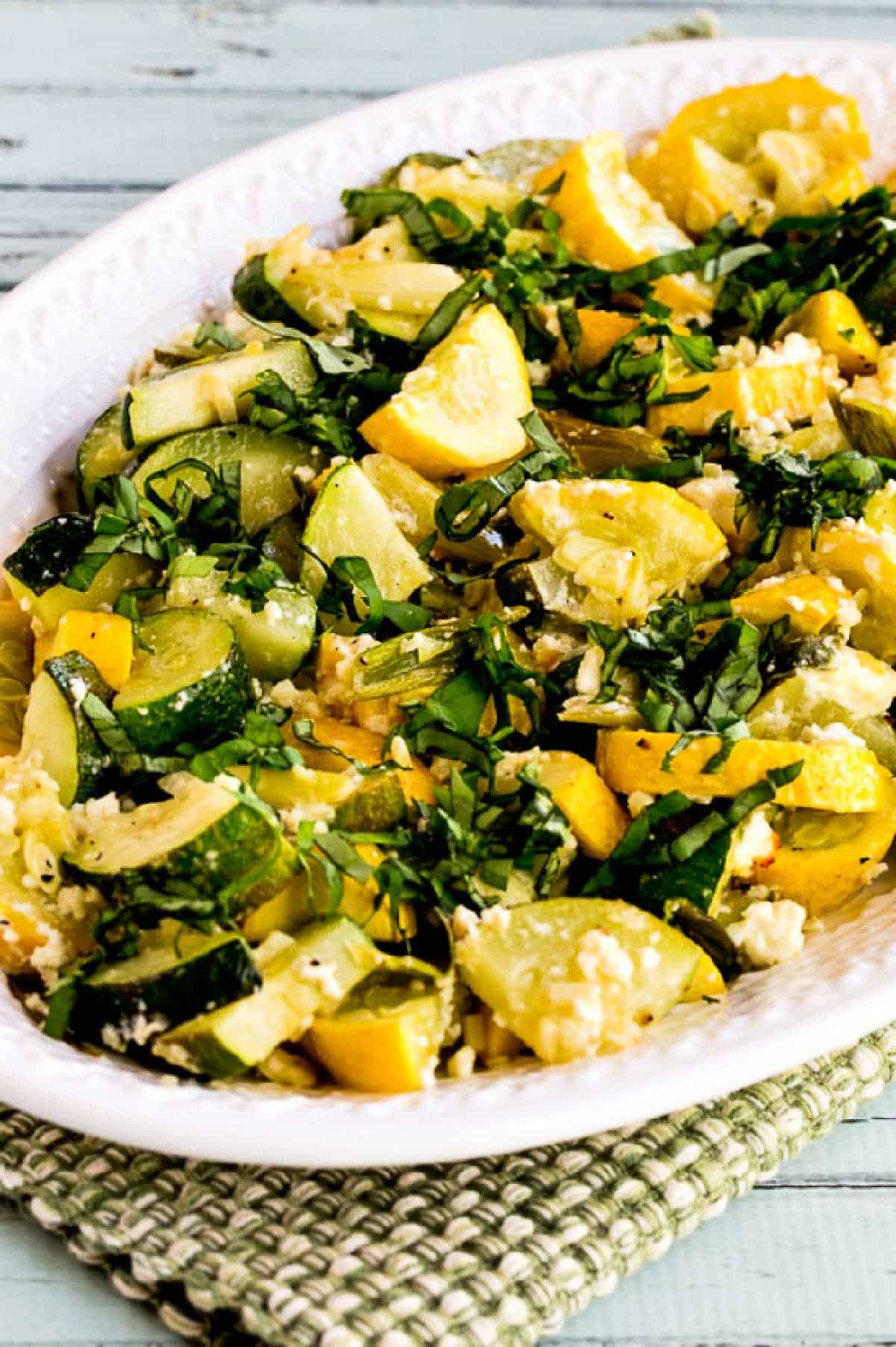 Roasted summer squash with feta, herbs and honey on a platter
